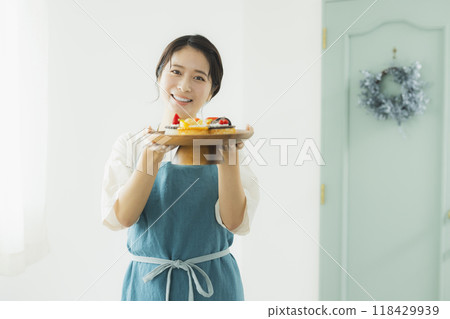 Woman in an apron holding sweets 118429939