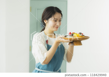 Woman in an apron holding sweets 118429940