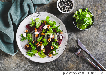 Delicious salad of beetroot, lettuce, nuts and ricotta on a plate on the table top view 118430134