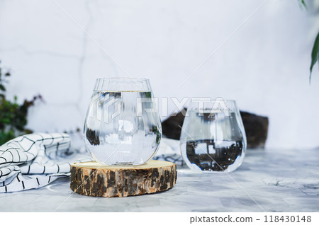 Clean organic water in glasses on table against background in shadows 118430148