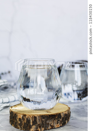 Clean organic water in glasses on table against background in shadows vertical view Clean organic water in glasses on table against background in shadows vertical view 118430150