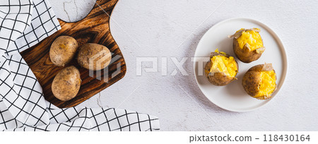 Appetizing jacket potatoes on a white plate on the table top view web banner 118430164