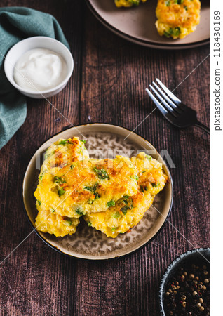 Crispy potato fritters with broccoli on a plate on the table vertical view Crispy potato fritters with broccoli on a plate on the table vertical view 118430169