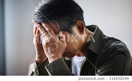 A man holding his head in worry (AI-generated image) A man holding his head in worry (AI-generated image) 118430294