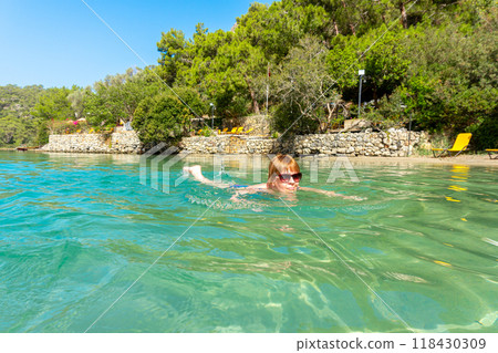 Woman Swimming in Turquoise Tropical Sea Woman Swimming in Turquoise Tropical Sea 118430309