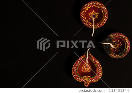 Top view of Diwali oil lamps on black background with space for text. 118431244