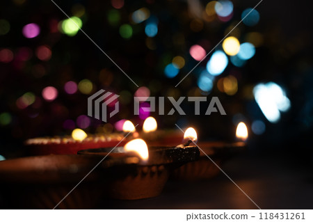 Happy Diwali - Glowing clay lanterns during Indian festival Diwali celebrations with bokeh effect background with copy space. 118431261
