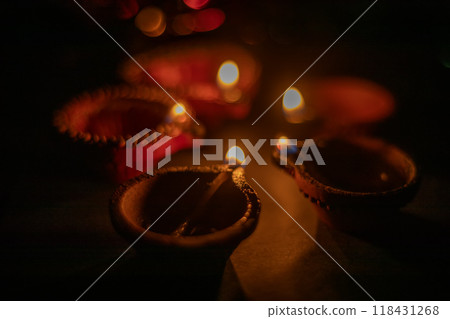 Glowing clay lamps during Indian festival Diwali celebrations on black background Glowing clay lamps during Indian festival Diwali celebrations on black background 118431268