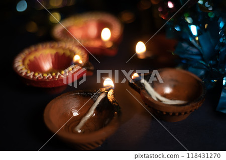 Glowing clay lamps during Indian festival Diwali celebrations on black background. Glowing clay lamps during Indian festival Diwali celebrations on black background. 118431270