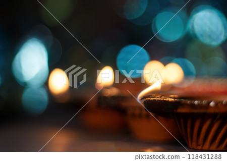 Clay diya lights lit during Diwali celebration with bokeh background. Clay diya lights lit during Diwali celebration with bokeh background. 118431288