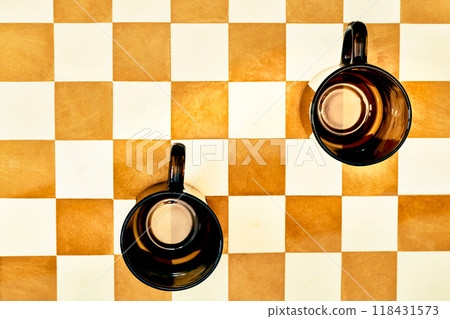 Two brown tea coffee cups on a chessboard.Pause 118431573