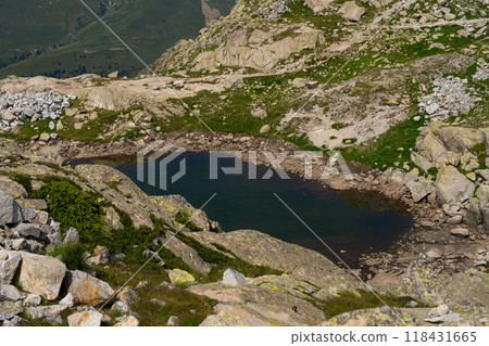 Hidden mountain lake surrounded by rocky terrain in alpine landscape 118431665