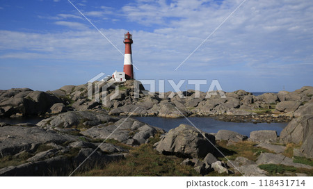 Red and white cast iron Eigeroy Lighthouse and anorthosite rock formations, Norway. Red and white cast iron Eigeroy Lighthouse and anorthosite rock formations, Norway. 118431714