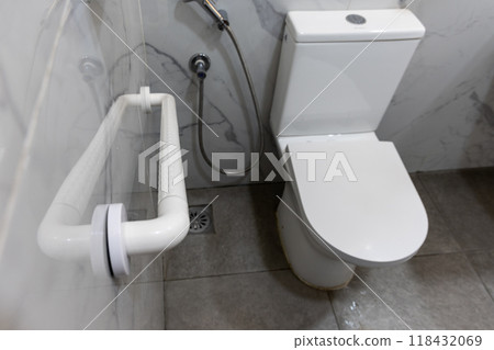 Hand rail fixture on wall inside wc next to toilet bowl to aid users with physical health mobility issue Hand rail fixture on wall inside wc next to toilet bowl to aid users with physical health mobility issue 118432069