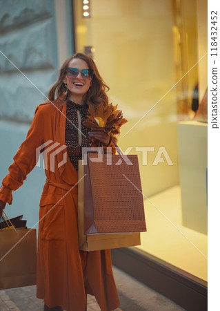 happy modern woman in orange trench coat happy modern woman in orange trench coat 118432452