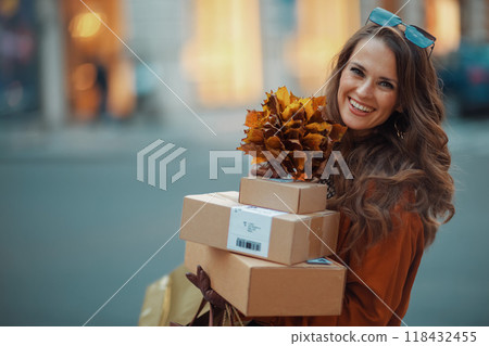 happy stylish woman in brown trench coat with parcels 118432455