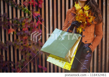 Closeup on trendy woman in orange trench coat 118432461