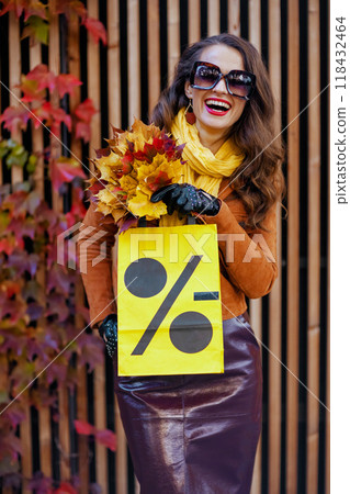 happy elegant woman in brown trench coat with shopping bag happy elegant woman in brown trench coat with shopping bag 118432464