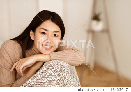 Relaxed Asian Girl Looking at Camera In Living Room, Having Rest at Home 118433047