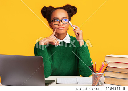 Brainstorming. Pensive black girl thinking about college, looking at copy space over yellow studio background Brainstorming. Pensive black girl thinking about college, looking at copy space over yellow studio background 118433146