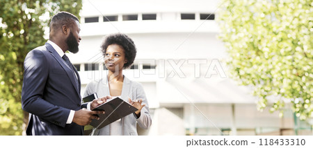 Couple of black business partners checking office documentation outdoors 118433310