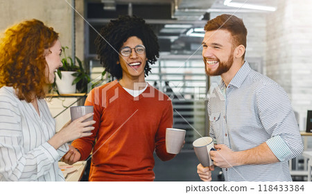 Enjoying free time. Group of millennial coworkers drinking coffee and talking in modern coworking space 118433384