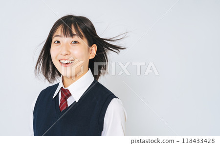A female student in uniform with her hair blowing in the wind 118433428