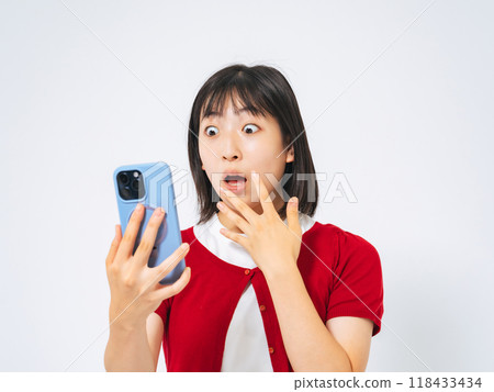 Surprised girl looking at smartphone 118433434