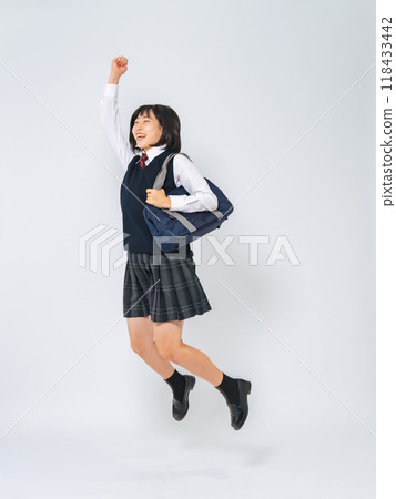 Full-body photo of a female student in uniform jumping energetically 118433442