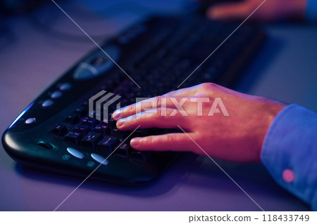Gamer Hands On Keyboard, Pushing Buttons, Playing Games Online. Illuminated With Neon Lights, Cropped Gamer Hands On Keyboard, Pushing Buttons, Playing Games Online. Illuminated With Neon Lights, Cropped 118433749