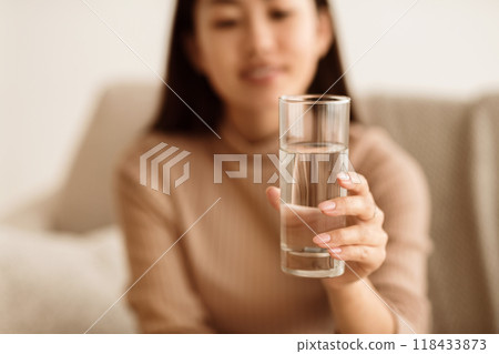 Healthcare Concept. Asian Girl Holding Glass of Mineral Water, Stretching to Camera 118433873