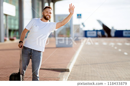 Arriving Home Concept. Tourist trying to catch taxi, waving and standing with baggage, copyspace Arriving Home Concept. Tourist trying to catch taxi, waving and standing with baggage, copyspace 118433879