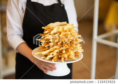Traditional Lithuanian cake in hands, selective focus in motion LITHUANIAN SAKOTIS CAKE baumkuchen Traditional Lithuanian cake in hands, selective focus in motion LITHUANIAN SAKOTIS CAKE baumkuchen 118433928