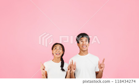 Happy students pointing and looking up on copy space, pink background 118434274