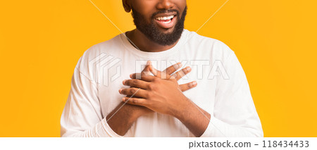 Cropped photo of african guy expressing his feelings, placing hands on chest, been touched with good attitude, panorama Cropped photo of african guy expressing his feelings, placing hands on chest, been touched with good attitude, panorama 118434433