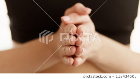 Cropped of sporty woman holding hands clasped tightly together, fingers intertwined, showing a gesture of unity or concentration. 118434503