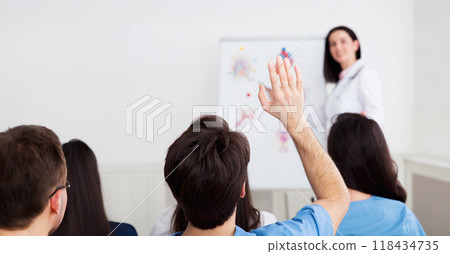 Medical lecture. Doctor giving presentation to practitioners, man having question 118434735
