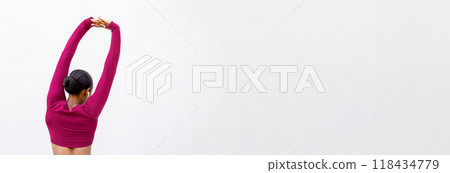 Rear view of athletic black lady with beautiful well-fit body wearing pink tight sportswear stretching arms on white blank wall background, panorama with copy space. Fitness, pilates, workout, sport 118434779