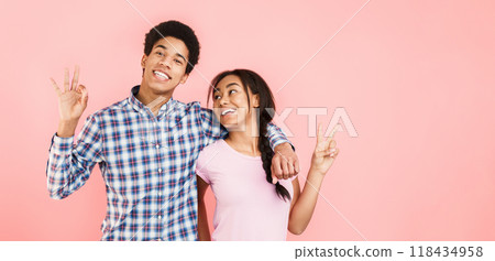 Happy students showing ok and peace gesture, posing over pink background Happy students showing ok and peace gesture, posing over pink background 118434958