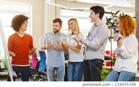 Business team appreciating colleague for explaining presentation, applauding in co-working space 118435149
