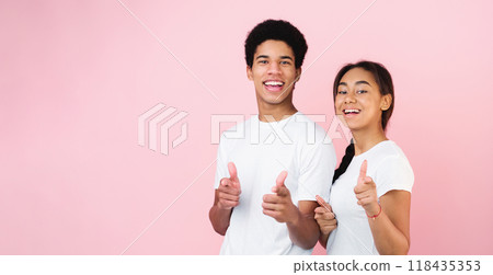 Gotcha. Teen couple pointing fingers at camera, posing on pink studio background Gotcha. Teen couple pointing fingers at camera, posing on pink studio background 118435353