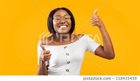 I Like It. Excited African American Girl Gesturing Thumbs Up With Both Hands Standing Over Orange Background. Panorama, Studio Shot I Like It. Excited African American Girl Gesturing Thumbs Up With Both Hands Standing Over Orange Background. Panorama, Studio Shot 118435439