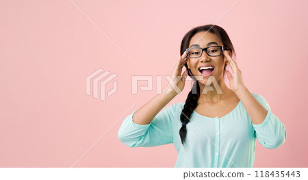 Happy student girl in glasses posing over pink studio background, crop 118435443
