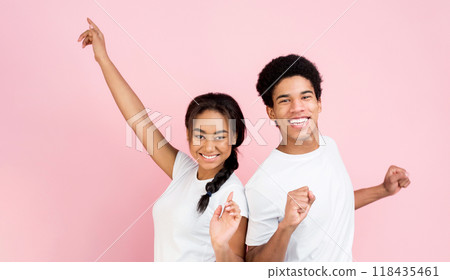 Overjoyed guy and girl dancing and laughing on pink studio background Overjoyed guy and girl dancing and laughing on pink studio background 118435461