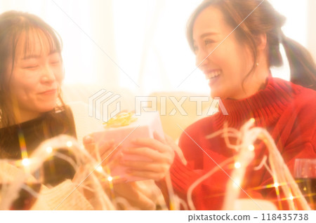 Two women exchanging gifts Two women exchanging gifts 118435738
