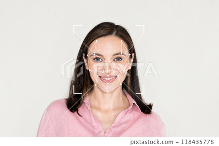 A woman smiles while facial recognition technology maps her features in a plain environment. 118435778