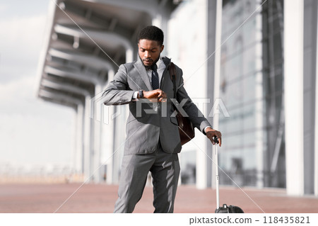 Business Traveler Checking Time On his Wristwatch At Airport, Walking Outdoors 118435821