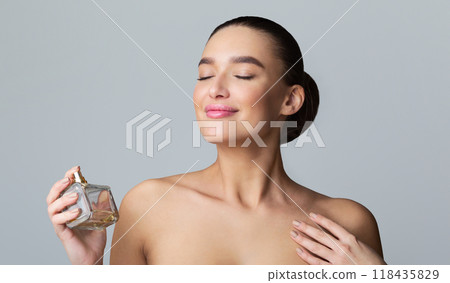 Beautiful Woman Spraying Perfume On Her Neck Over Grey Background Beautiful Woman Spraying Perfume On Her Neck Over Grey Background 118435829