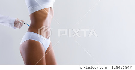 Beauty procedure. Afro woman having lipolysis treatment for waist at beauty salon, close up Beauty procedure. Afro woman having lipolysis treatment for waist at beauty salon, close up 118435847