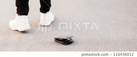 Lost cash concept. Man accidently dropped his leather wallet with money on the street, panorama, copy space Lost cash concept. Man accidently dropped his leather wallet with money on the street, panorama, copy space 118436012